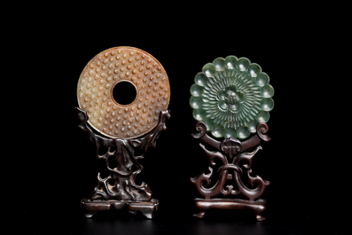 A Chinese russet jade 'bi' disc and a spinach-green flower-shaped pendant on wooden stands, Ming and Qing