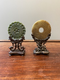 A Chinese russet jade 'bi' disc and a spinach-green flower-shaped pendant on wooden stands, Ming and Qing