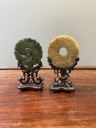 A Chinese russet jade 'bi' disc and a spinach-green flower-shaped pendant on wooden stands, Ming and Qing