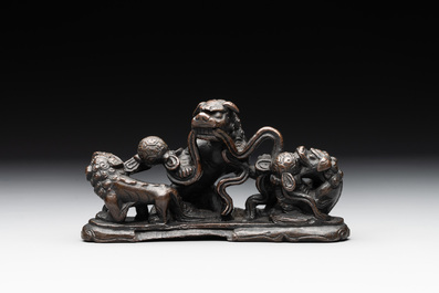 A rare Chinese bronze 'three dancing lions' paperweight or brush rest, Ming