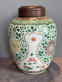 A Chinese famille verte jar with floral design and a wooden cover, Kangxi
