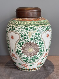 A Chinese famille verte jar with floral design and a wooden cover, Kangxi