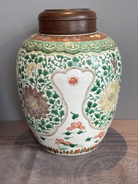 A Chinese famille verte jar with floral design and a wooden cover, Kangxi