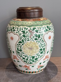 A Chinese famille verte jar with floral design and a wooden cover, Kangxi