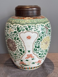 A Chinese famille verte jar with floral design and a wooden cover, Kangxi