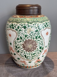 A Chinese famille verte jar with floral design and a wooden cover, Kangxi