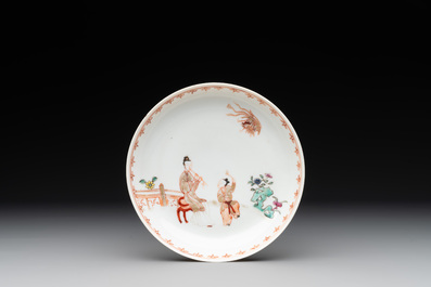 A Chinese famille rose cup and saucer with a lady playing flute, a boy and a phoenix, Qianlong