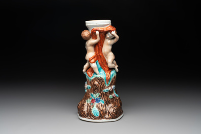 A Chinese export faux-bois stand with two putti and two famille rose boys, Qianlong/Jiaqing
