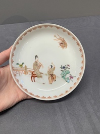 A Chinese famille rose cup and saucer with a lady playing flute, a boy and a phoenix, Qianlong