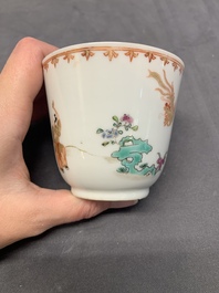 A Chinese famille rose cup and saucer with a lady playing flute, a boy and a phoenix, Qianlong