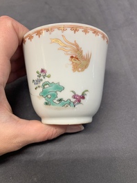 A Chinese famille rose cup and saucer with a lady playing flute, a boy and a phoenix, Qianlong