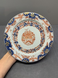Two Chinese famille rose plates and an Imari-style armorial plate, Kangxi/Yongzheng