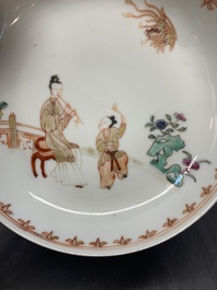A Chinese famille rose cup and saucer with a lady playing flute, a boy and a phoenix, Qianlong