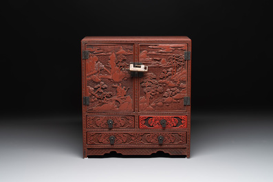 A Chinese cinnabar lacquer 'mountainous landscape' cabinet, 19th C.
