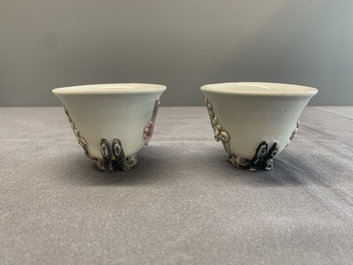 A pair of Chinese Dehua blanc de Chine relief-decorated famille rose 'prunus' cups, 19th C.