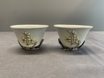 A pair of Chinese Dehua blanc de Chine relief-decorated famille rose 'prunus' cups, 19th C.