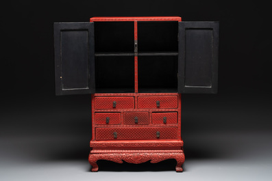 A Chinese cinnabar lacquer 'mountainous landscape' cabinet on a stand, 19th C.