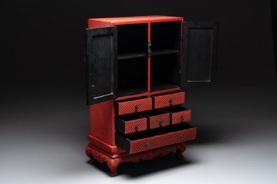 A Chinese cinnabar lacquer 'mountainous landscape' cabinet on a stand, 19th C.