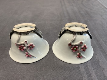 A pair of Chinese Dehua blanc de Chine relief-decorated famille rose 'prunus' cups, 19th C.