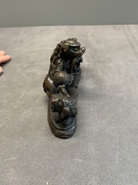 A rare Chinese bronze 'three dancing lions' paperweight or brush rest, Ming