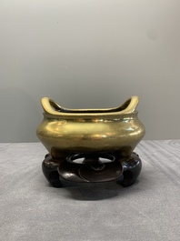 A Chinese bronze tripod censer on a wooden stand, Song Zhu Xuan 松竹軒 mark, 18th C.