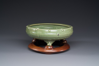 A Chinese Longquan celadon tripod censer on wooden stand, Yuan/Ming