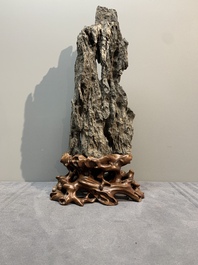A Chinese ying stone scholar's rock on wooden stand, 20th C.