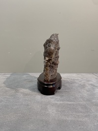 A Chinese grape agate scholar's rock on wooden stand, 20th C.