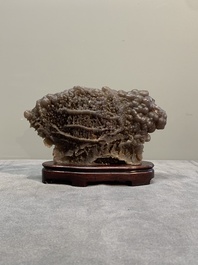 A Chinese grape agate scholar's rock on wooden stand, 20th C.