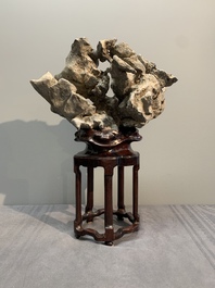 A Chinese Taihu stone scholar's rock on wooden stand, 20th C.