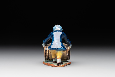 A polychrome Dutch Delft model of a boy rolling a 'wijn azijn' barrel, 18th C.