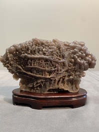 A Chinese grape agate scholar's rock on wooden stand, 20th C.
