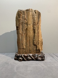 A Chinese petrified wood scholar's rock on wooden stand, 17/18th C.