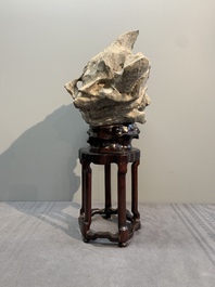 A Chinese Taihu stone scholar's rock on wooden stand, 20th C.