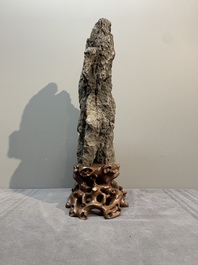 A Chinese ying stone scholar's rock on wooden stand, 20th C.