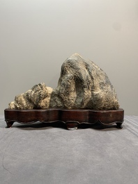 A Chinese Lingbi stone scholar's rock on wooden stand, 20th C.