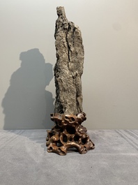 A Chinese ying stone scholar's rock on wooden stand, 20th C.