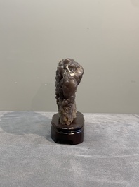 A Chinese grape agate scholar's rock on wooden stand, 20th C.