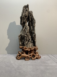A Chinese ying stone scholar's rock on wooden stand, 20th C.
