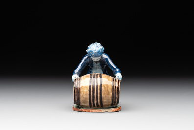 A polychrome Dutch Delft model of a boy rolling a 'wijn azijn' barrel, 18th C.