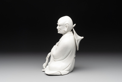 A Chinese Dehua blanc de Chine Luohan on wooden stand, 19/20th C.