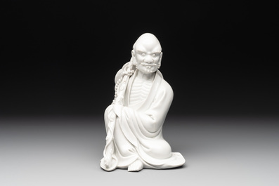 A Chinese Dehua blanc de Chine Luohan on wooden stand, 19/20th C.