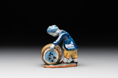 A polychrome Dutch Delft model of a boy rolling a 'wijn azijn' barrel, 18th C.
