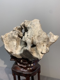 A Chinese Taihu stone scholar's rock on wooden stand, 20th C.