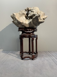 A Chinese Taihu stone scholar's rock on wooden stand, 20th C.