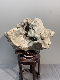 A Chinese Taihu stone scholar's rock on wooden stand, 20th C.