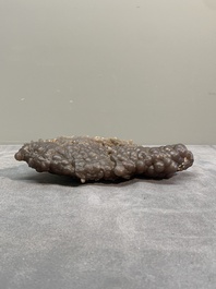 A Chinese grape agate scholar's rock on wooden stand, 20th C.