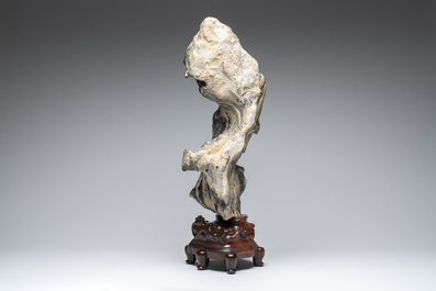 A Chinese green Lingbi stone scholar's rock on wooden stand, 20th C.
