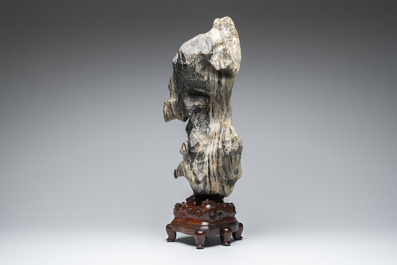 A Chinese green Lingbi stone scholar's rock on wooden stand, 20th C.