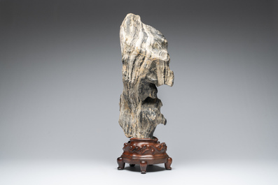 A Chinese green Lingbi stone scholar's rock on wooden stand, 20th C.